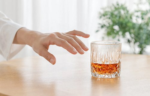 Рука тянется к алкоголю